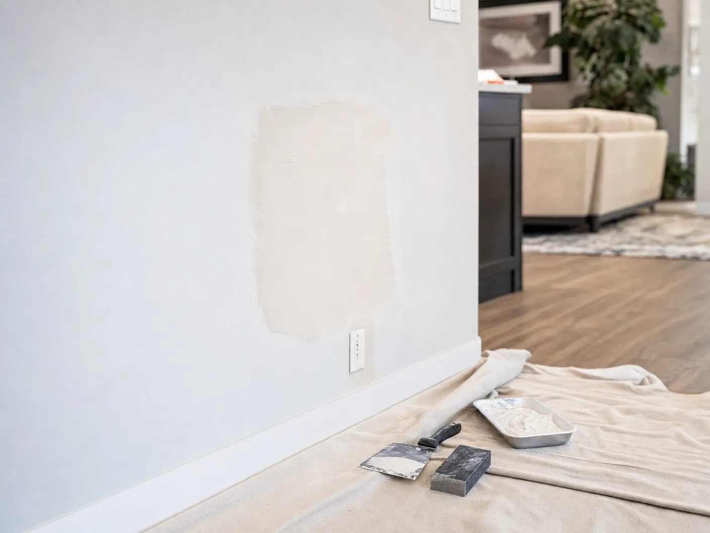 Drywall repair in a Southern Utah home with patching tools and a clean protected work area.