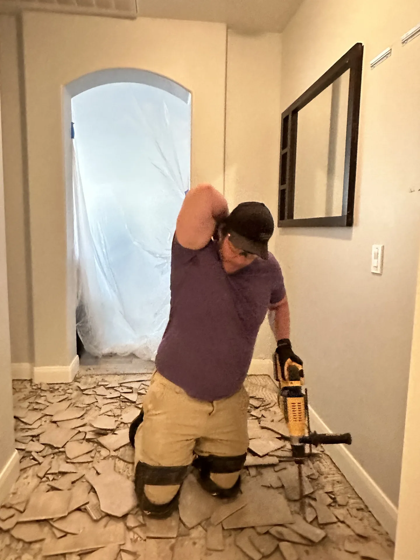 Viking Solutions crew member using rotary hammer to demo old tile in St. George home
