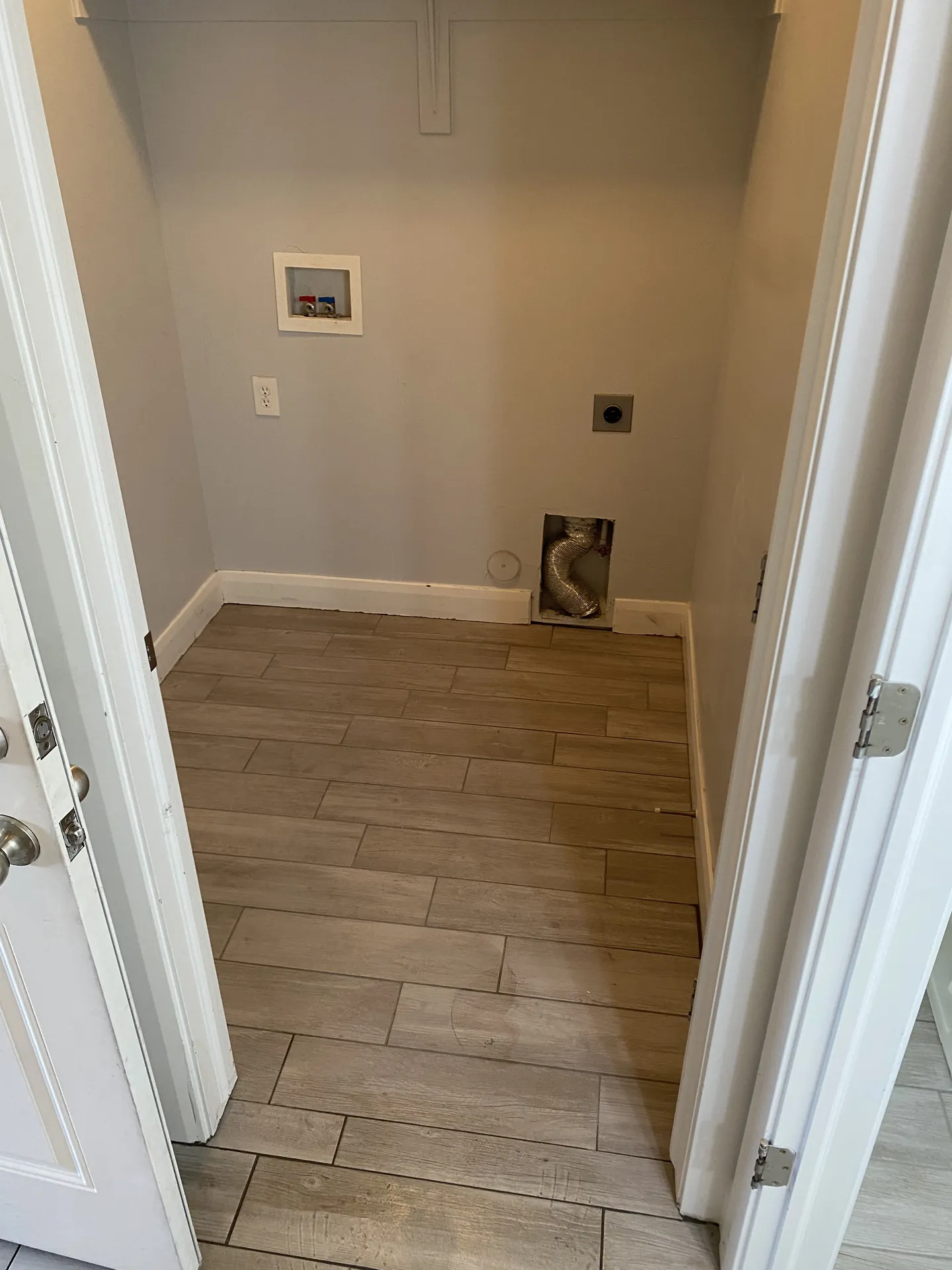 Finished laundry room with new wood-look plank tile — clean and bright