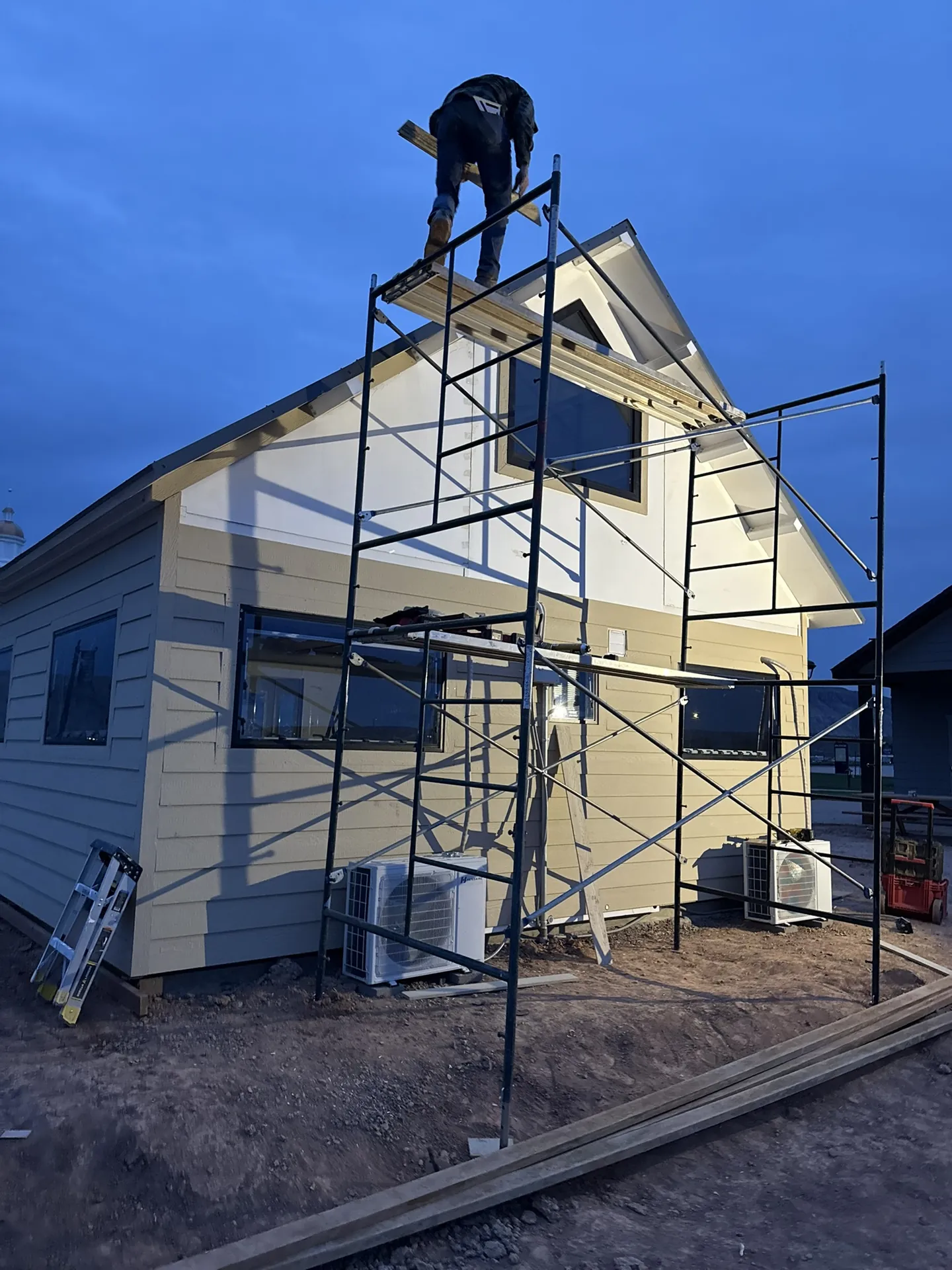 Viking Solutions crew working on scaffolding at dusk — Boxabl siding project Liberty Village Hurricane Utah