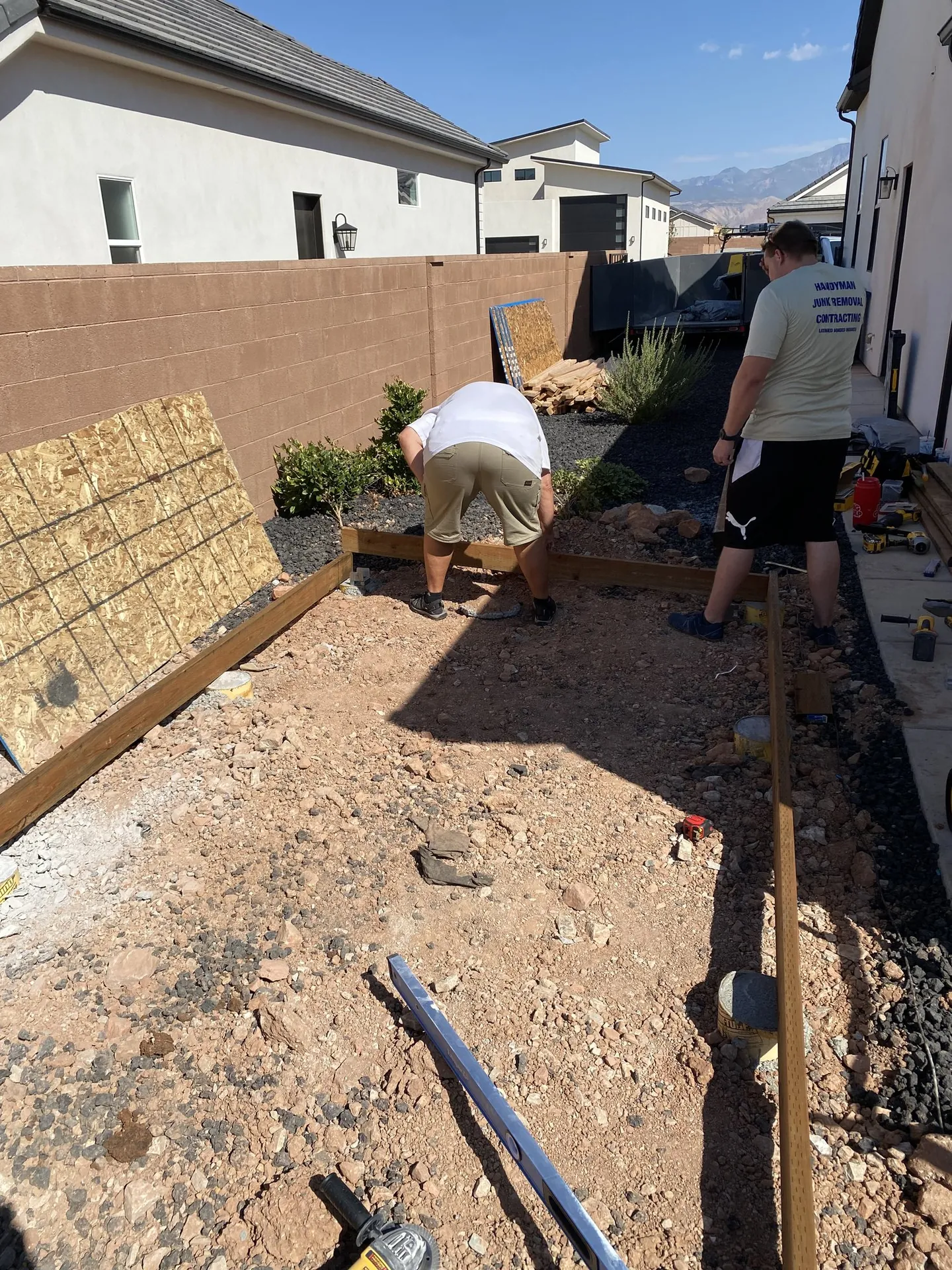 Viking Solutions shed build — two crew members laying floor frame with mountains visible in background