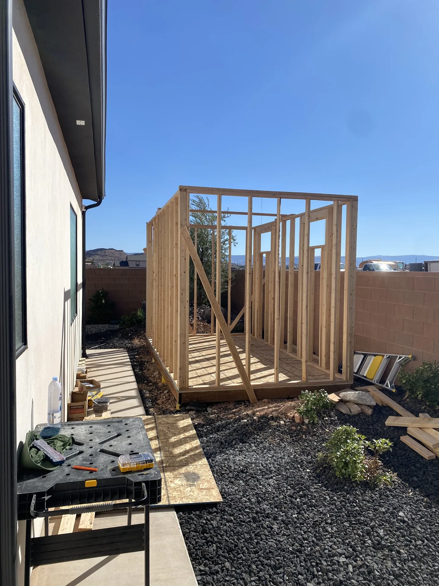 Viking Solutions shed build — all four walls framed with open roof, blue sky and mountains behind