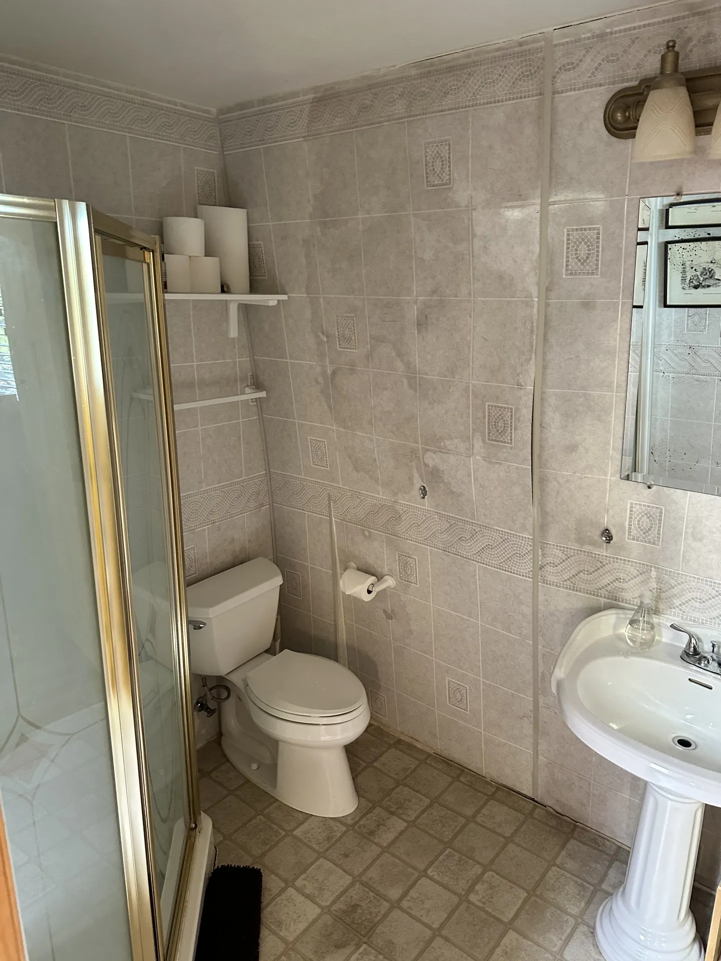 Bathroom before remodel — second angle showing toilet, pedestal sink, and mosaic tile border