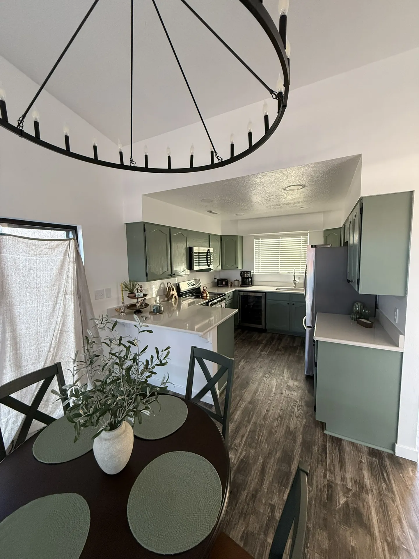 Complete condo remodel in St. George — finished kitchen with sage green cabinets, white quartz countertops, and dark LVP floors by Viking Solutions