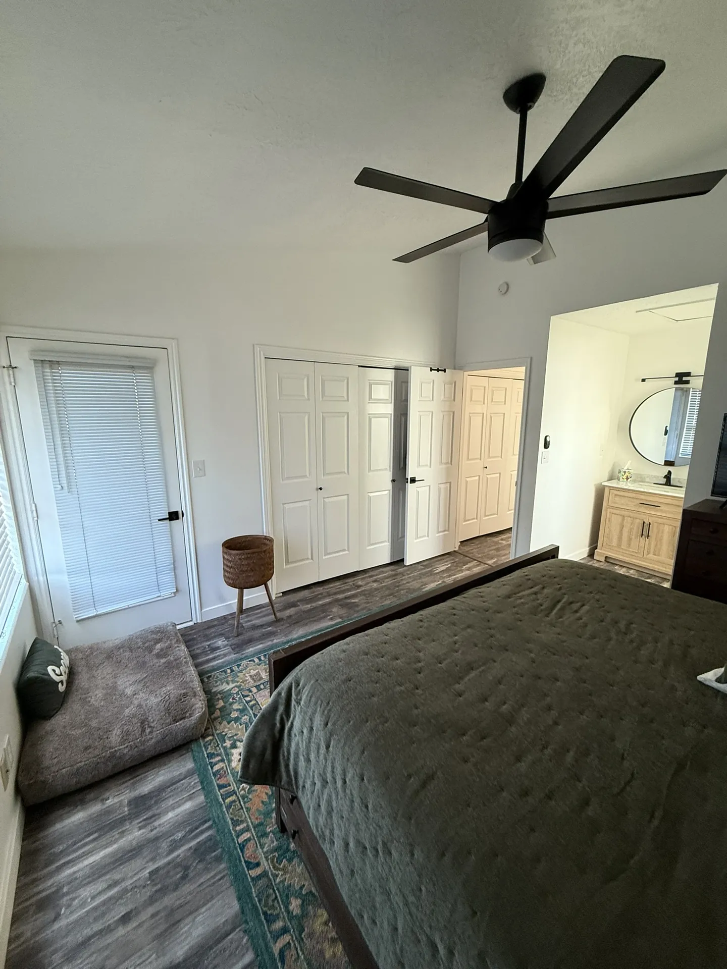 Condo after remodel — master bedroom with new dark LVP floors, new ceiling fan, and clean white walls