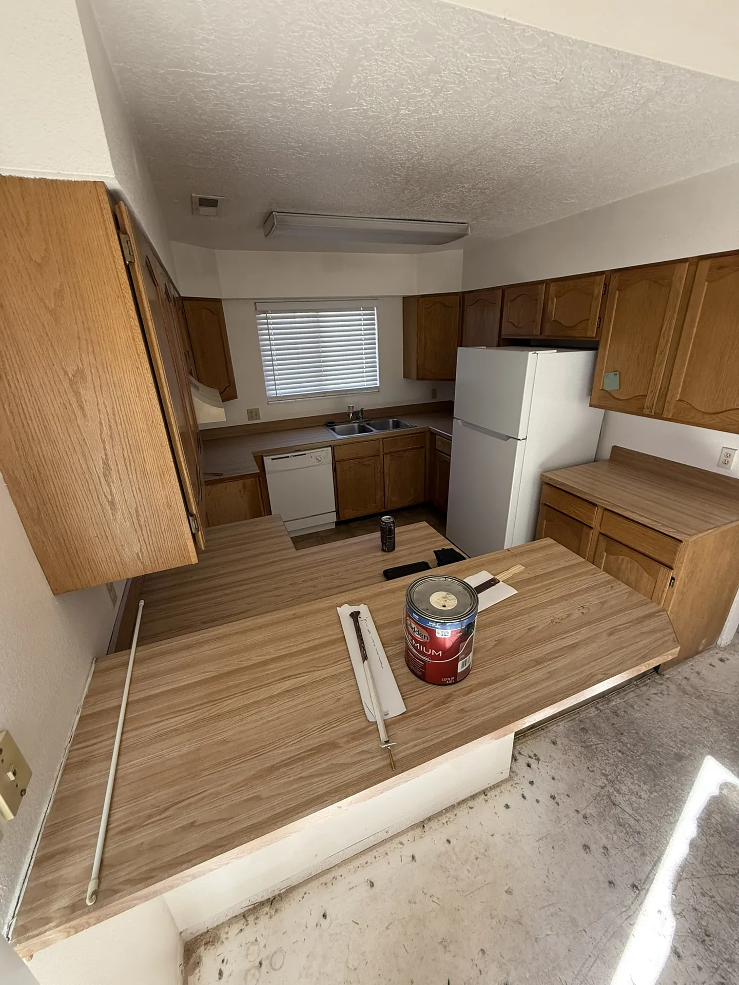 Condo before remodel — kitchen with original honey oak cabinets, old countertops, and dated appliances