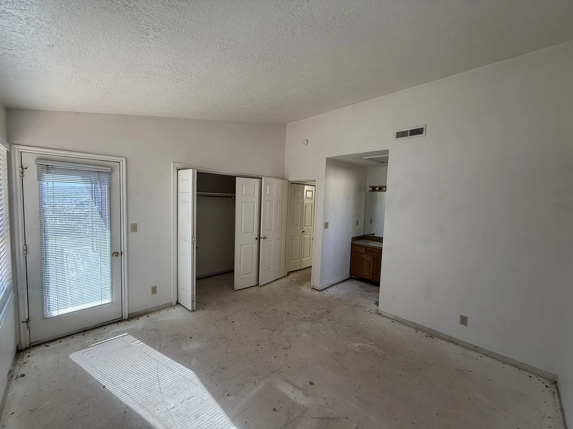 Condo before remodel — master bedroom with original carpet and dated finishes
