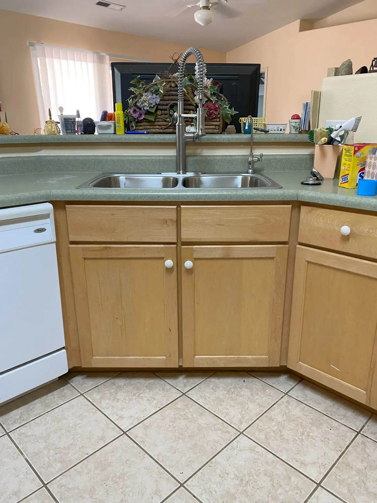 Kitchen sink after faucet replacement — same composite sink with new modern stainless pull-down faucet installed