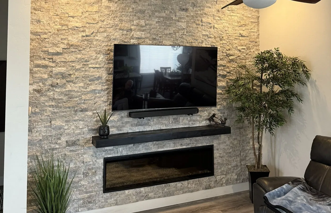 Custom fireplace wall build in Washington County — black shiplap, live-edge mantel, and LED hearth platform by Viking Solutions