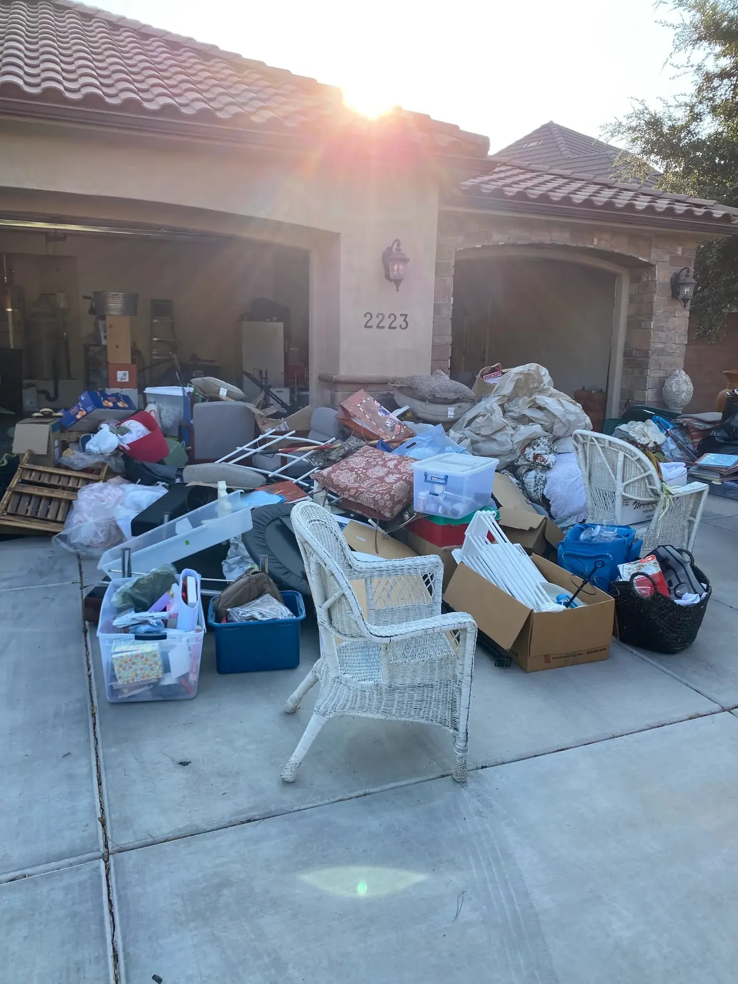 Driveway full of furniture, boxes, and household items staged for junk removal — Viking Solutions St. George