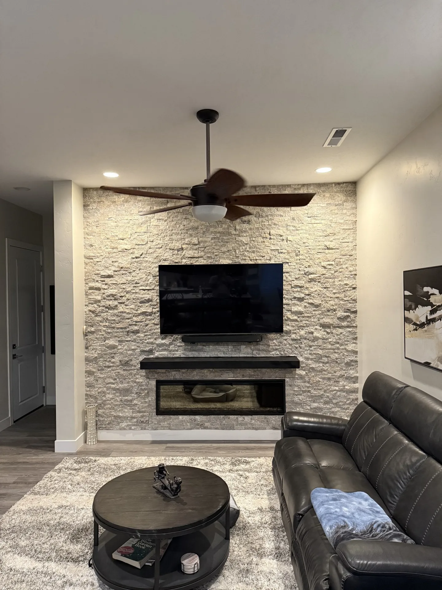 Angled view of ledger stone fireplace wall showing how it wraps the room corner