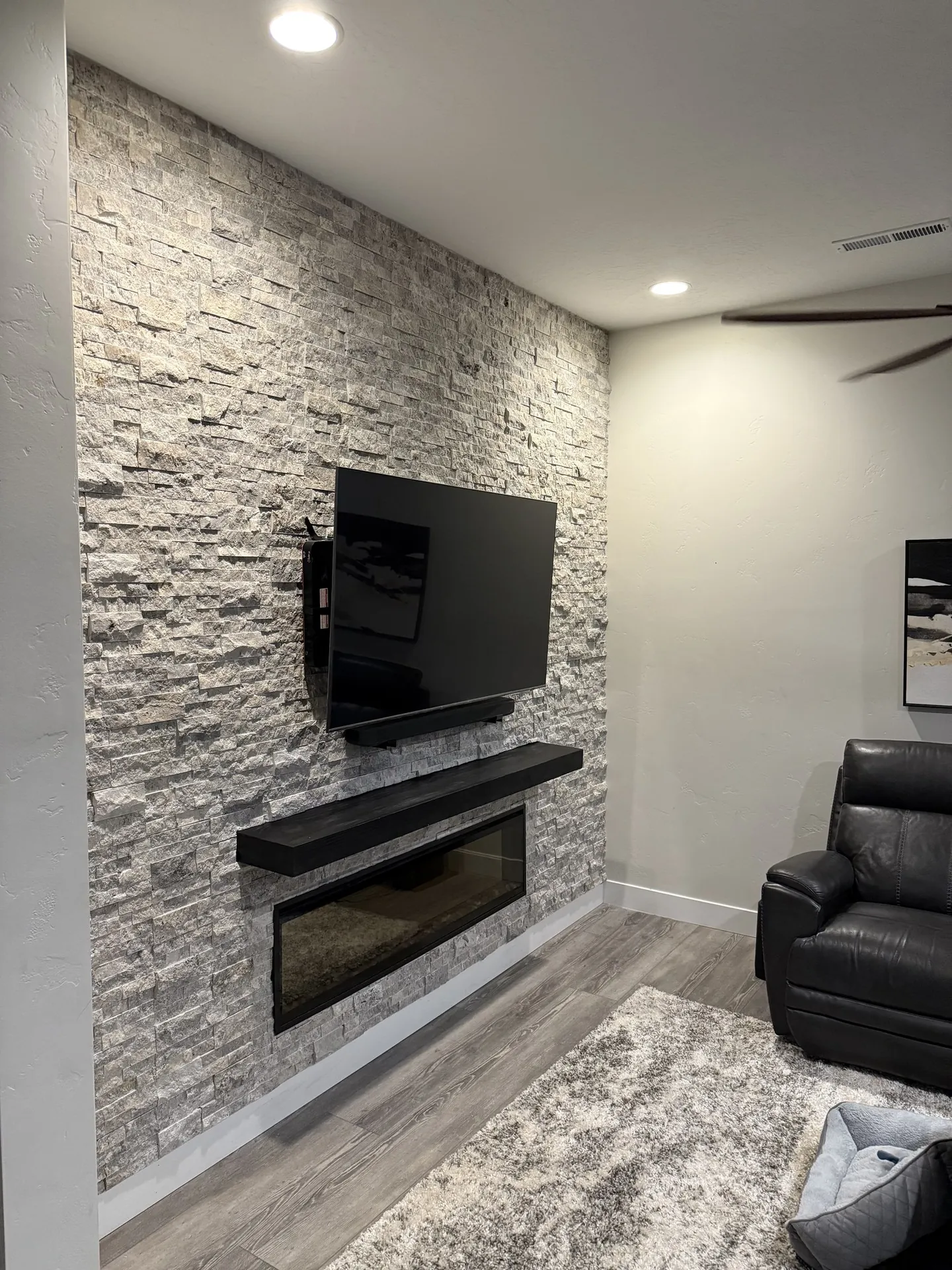 Close-up of stacked ledger stone texture on fireplace wall — gray and cream tones