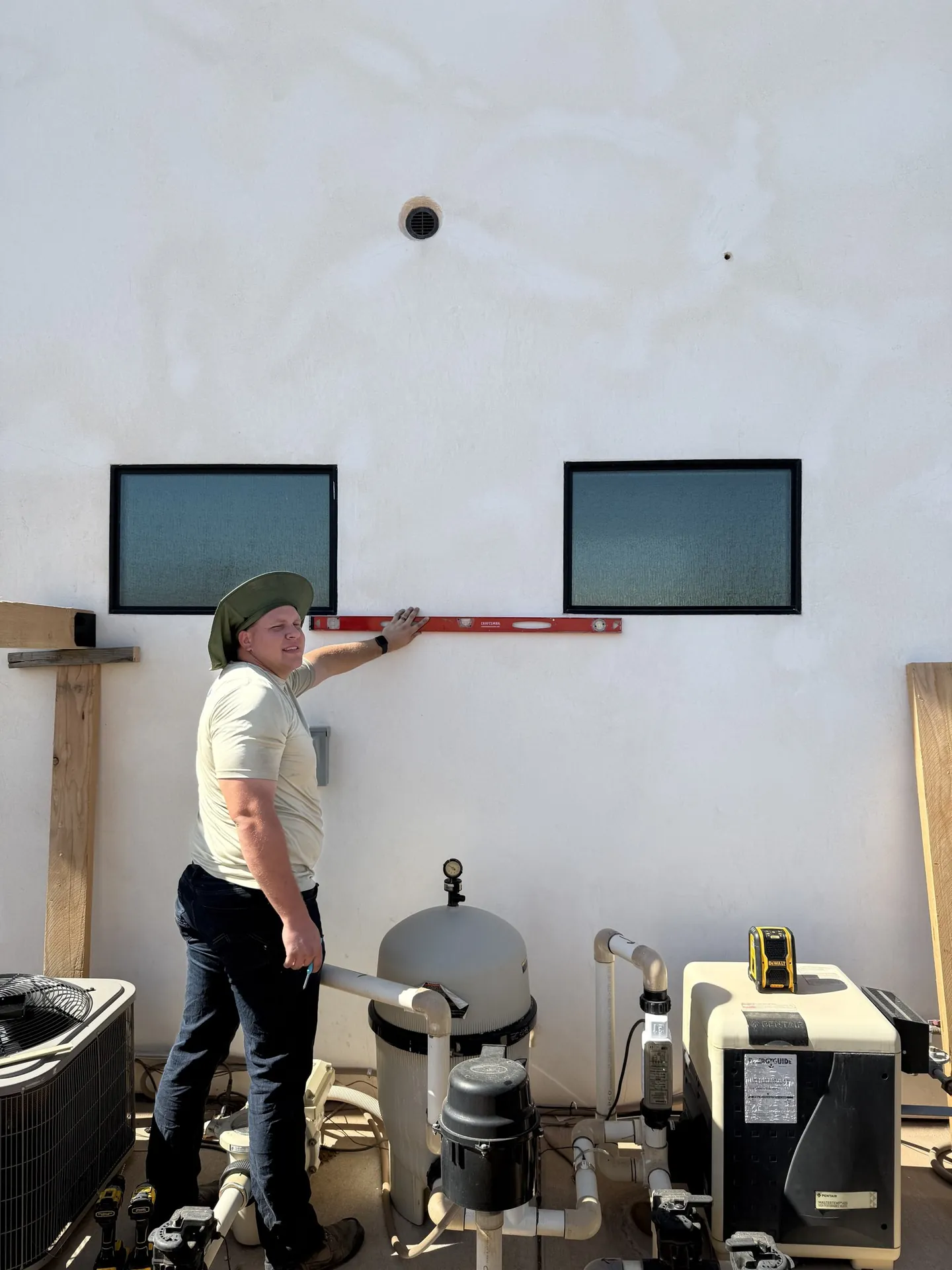 Viking Solutions crew member leveling the ledger board against the house wall before post installation