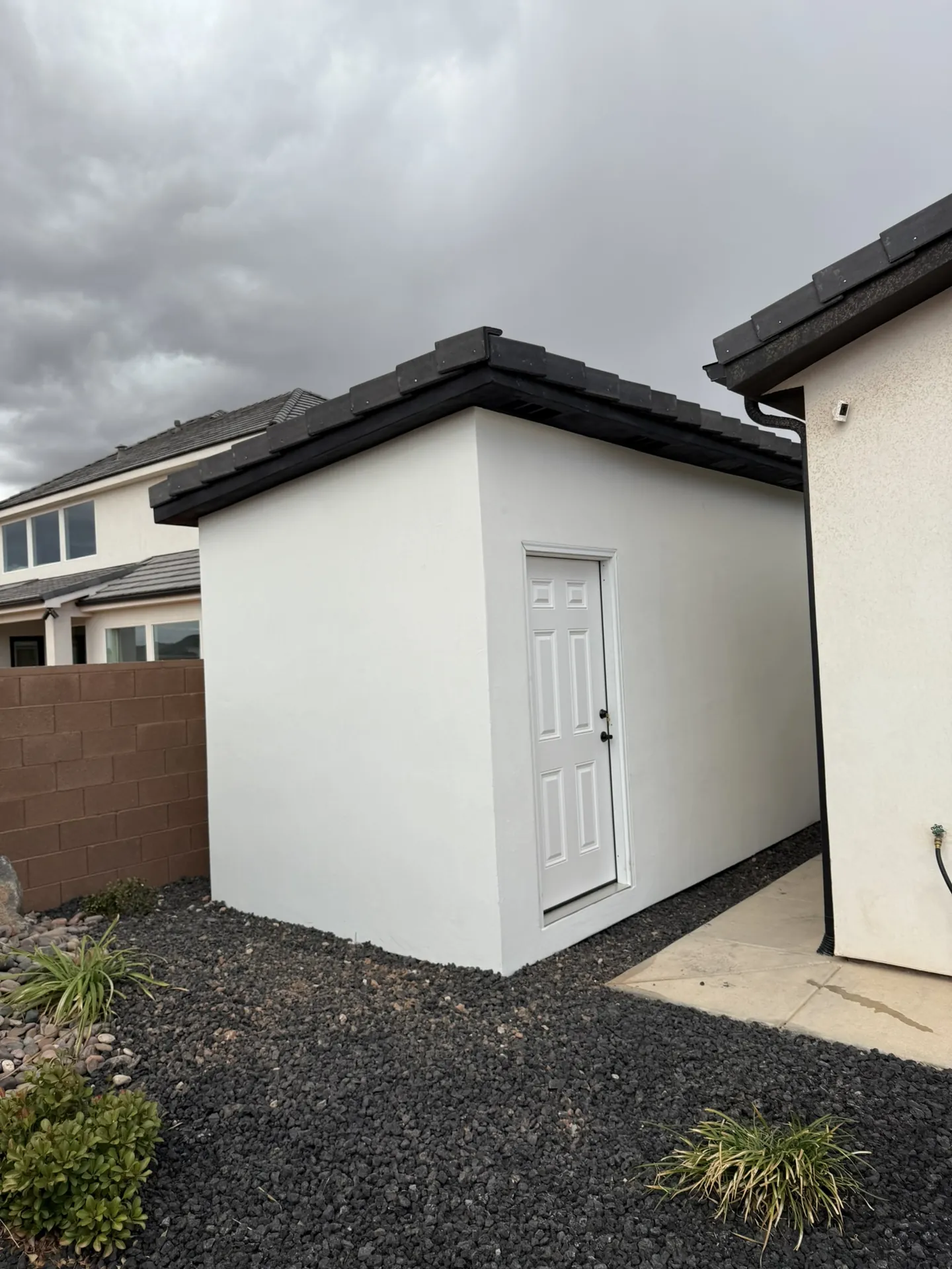 Custom shed build in St. George, Utah — white stucco exterior with dark tile roof by Viking Solutions