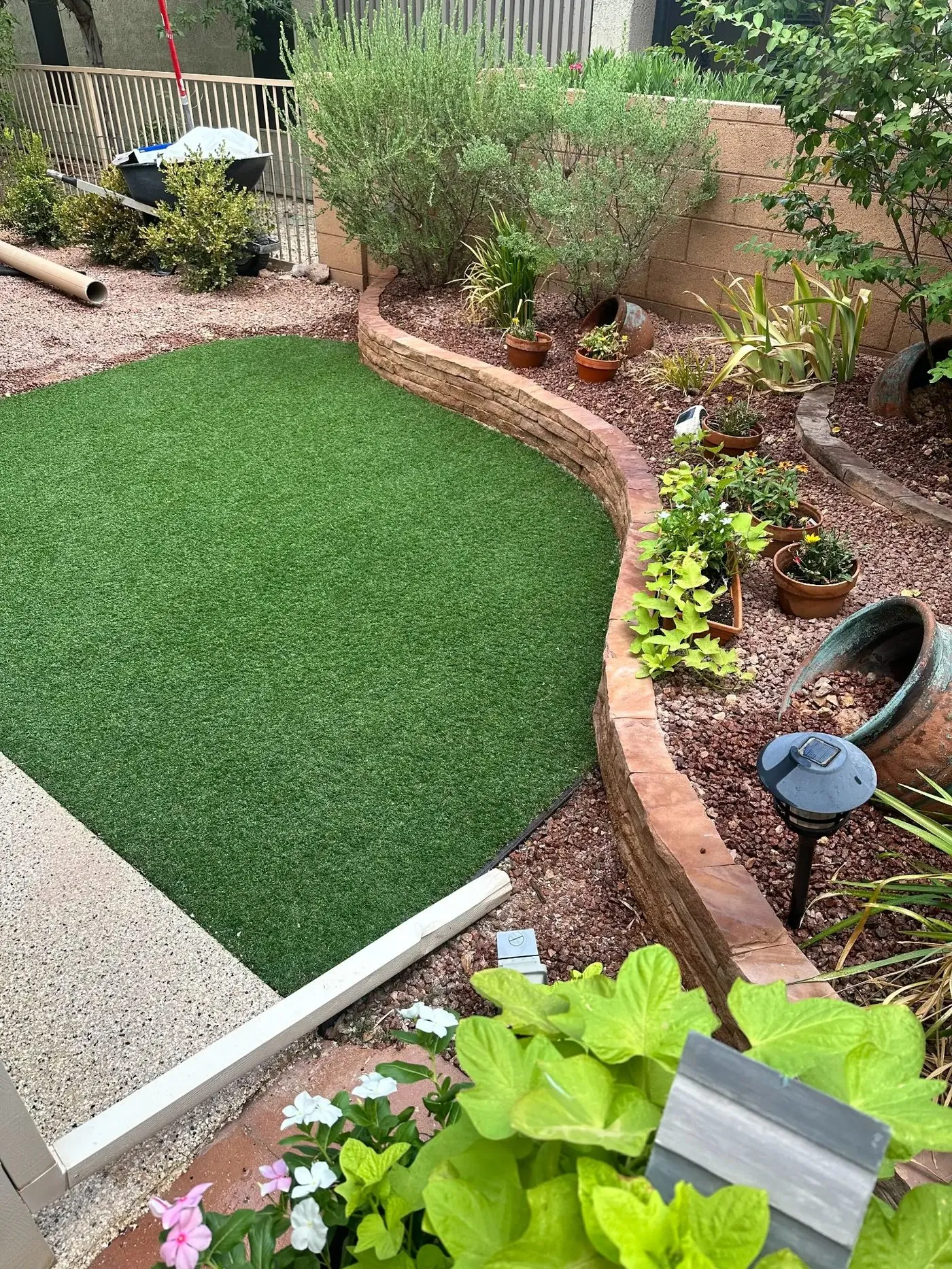 Overhead view of finished artificial turf in St. George — turf partially installed, curved retaining wall border visible