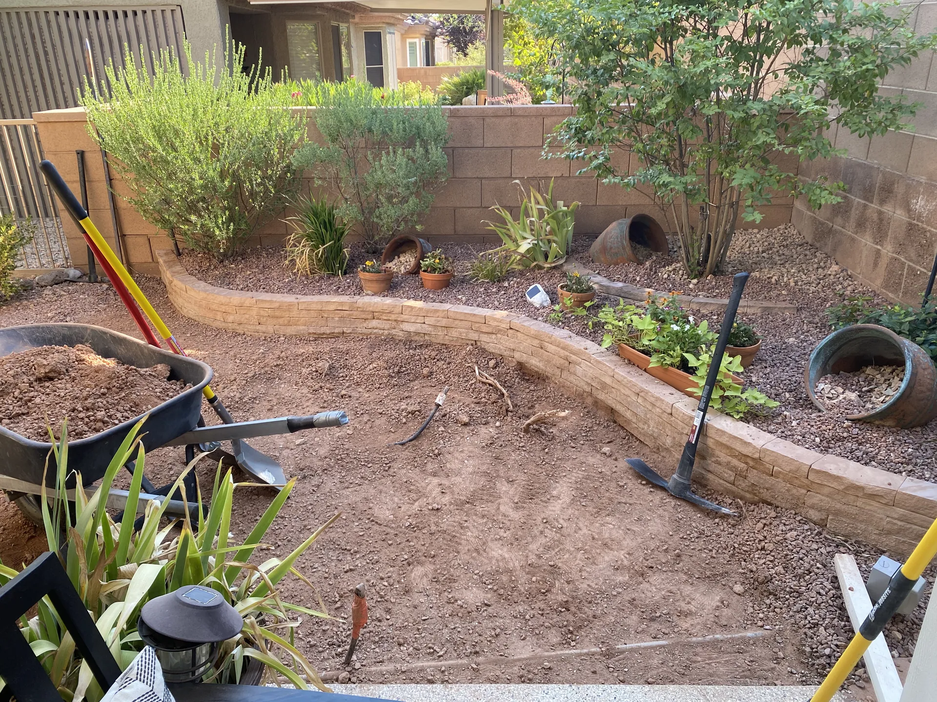 Finished artificial turf installation in St. George, Utah — full backyard view with lush green turf, curved retaining wall border, and desert landscaping