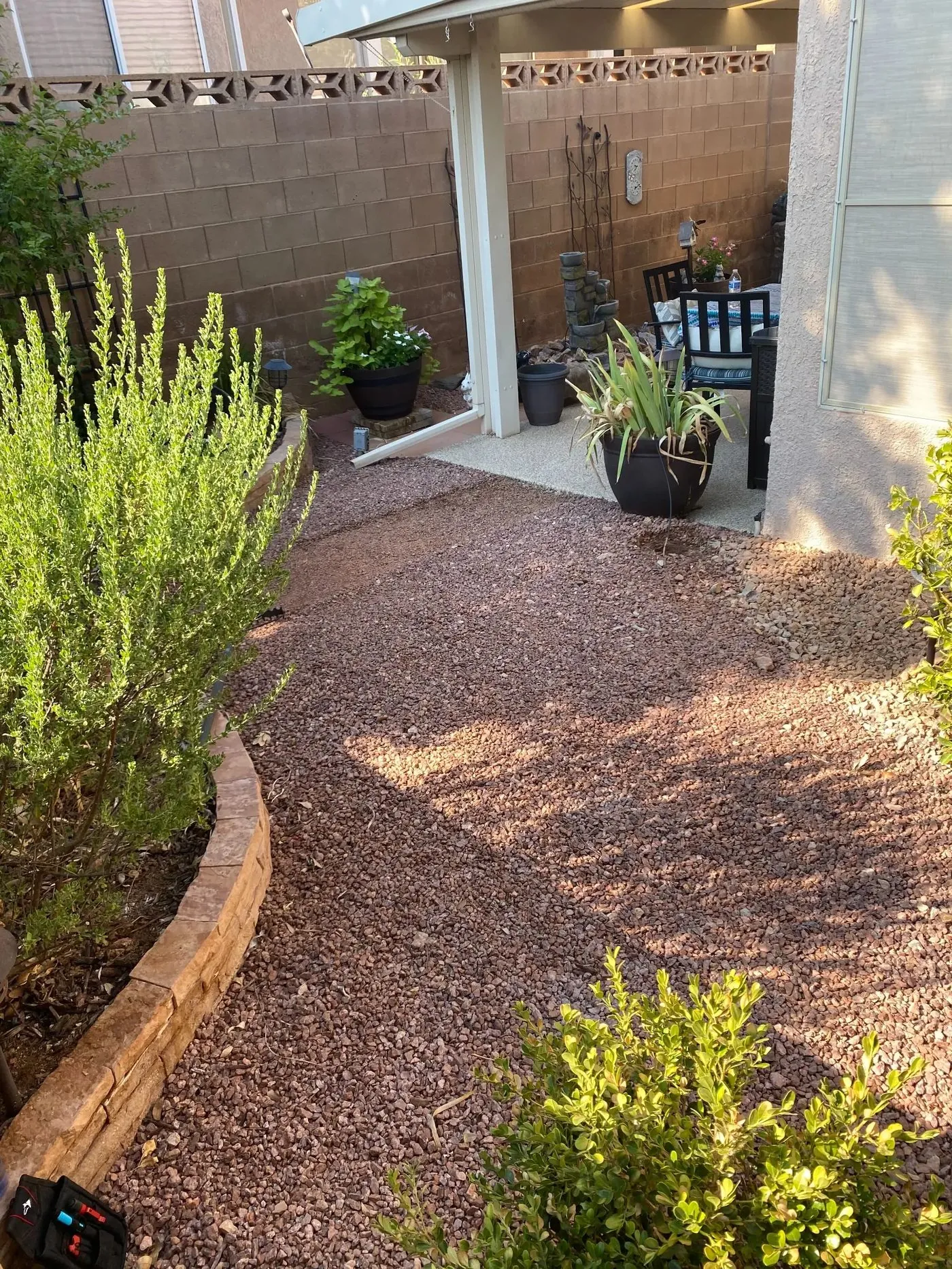 Before: gravel yard from patio angle — covered patio and desert landscaping visible