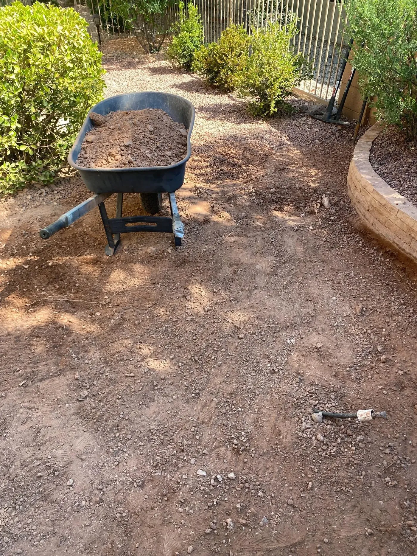 Excavation in progress — wheelbarrow loaded with decomposed granite being removed from St. George backyard